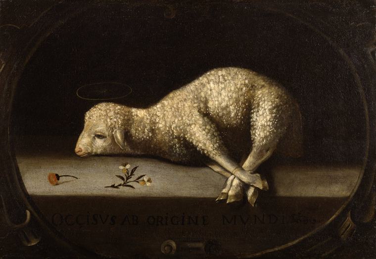 Painting of a white woolly lamb with a thin golden halo lying on a gray stone slab with its legs tied, two small flowers beside it and a Latin inscription below, inside a dark oval frame.