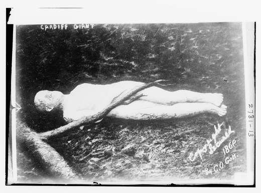 Eine große geschnitzte Gipsfigur eines Mannes, die ausgestellt auf dem Rücken liegt.