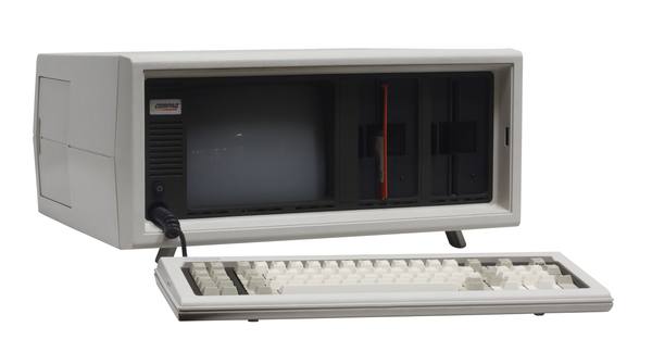 A cream-colored Compaq Portable computer with a small built-in screen and two floppy drives, its keyboard detached in front, photographed against a white background.