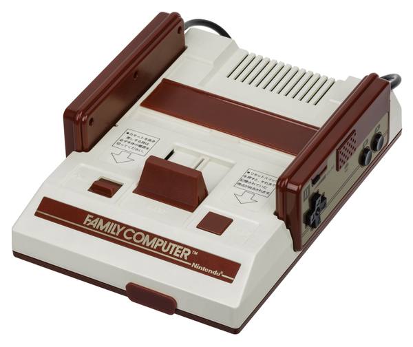 A cream-white and dark-red Nintendo Family Computer console with its two controllers docked in the sides and the Family Computer name on the front, photographed against a white background.