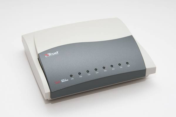 A light grey and dark grey external modem labelled Trust ESP-2 56k, with a row of small indicator lights along its front panel, photographed on a plain white background.