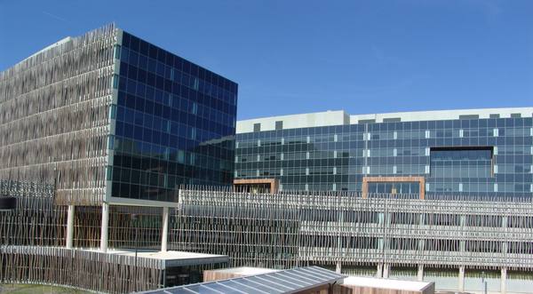 Glass and metal-louvered office buildings under a deep blue sky, with the words United States Census Bureau on the entrance canopy at the lower left of center.