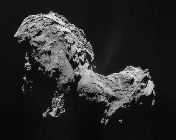 A grey, rugged, two-lobed comet nucleus against black space, with faint streaks of dust coming off its surface.