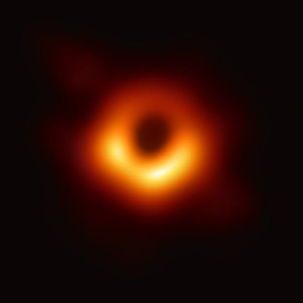 A blurry, glowing orange ring, brightest at the bottom, around a dark centre on a black background.